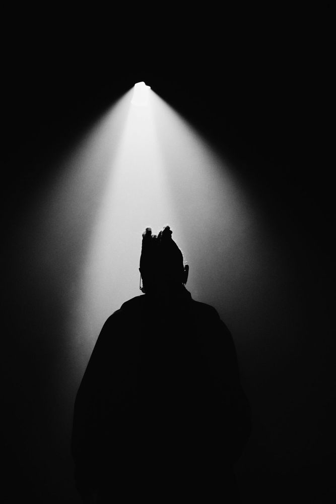 A figure under a single spotlight